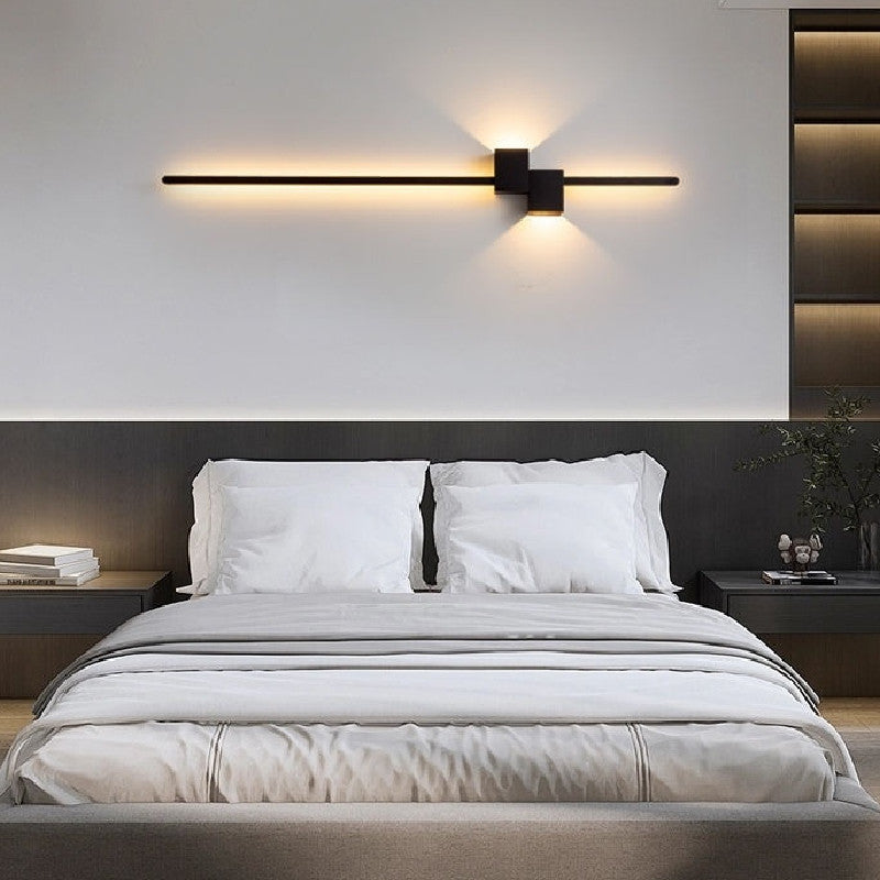 Minimalist linear bedside wall lamp in a bedroom setting